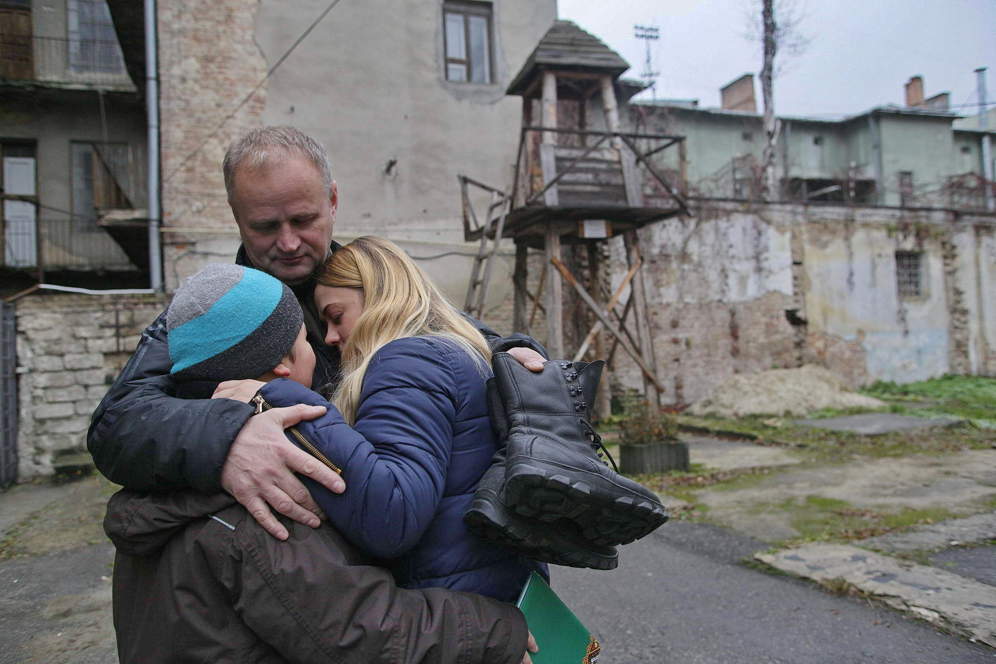 Serhiy Kodman (C) hugs his daughter and grandson in Ternopil on Nov. 29. He also carries boots that belong to his son Oleksiy, a soldier of the 56th Brigade, who has been imprisoned in the Russian-occupied part of Donetsk Oblast for more than two years. (Rostyslav Kovalchuk)