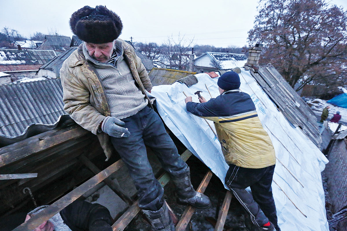 Civilians repair the roof of a house damaged by shelling in the city of Avdiyivka in Donetsk Oblast on Feb. 5. Avdiyivka, located close to Russian-occupied Donetsk, has become an epicenter of hostilities in 2017. (Volodymyr Petrov) 