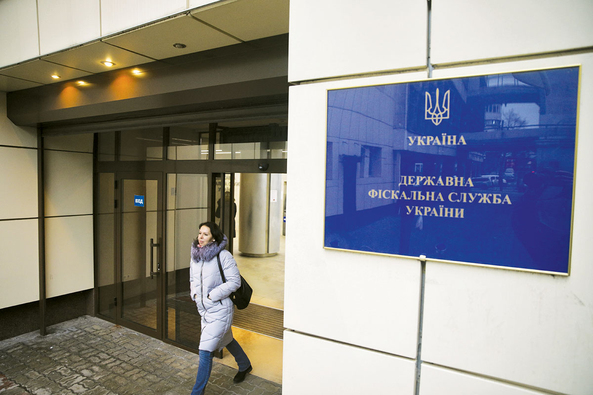 A woman leaves the State Fiscal Service building on Dec. 13 in Kyiv. Ukrainian businesses complain about the taxation and customs service more than any other government body, according to Business Ombudsman Algirdas Semeta. 