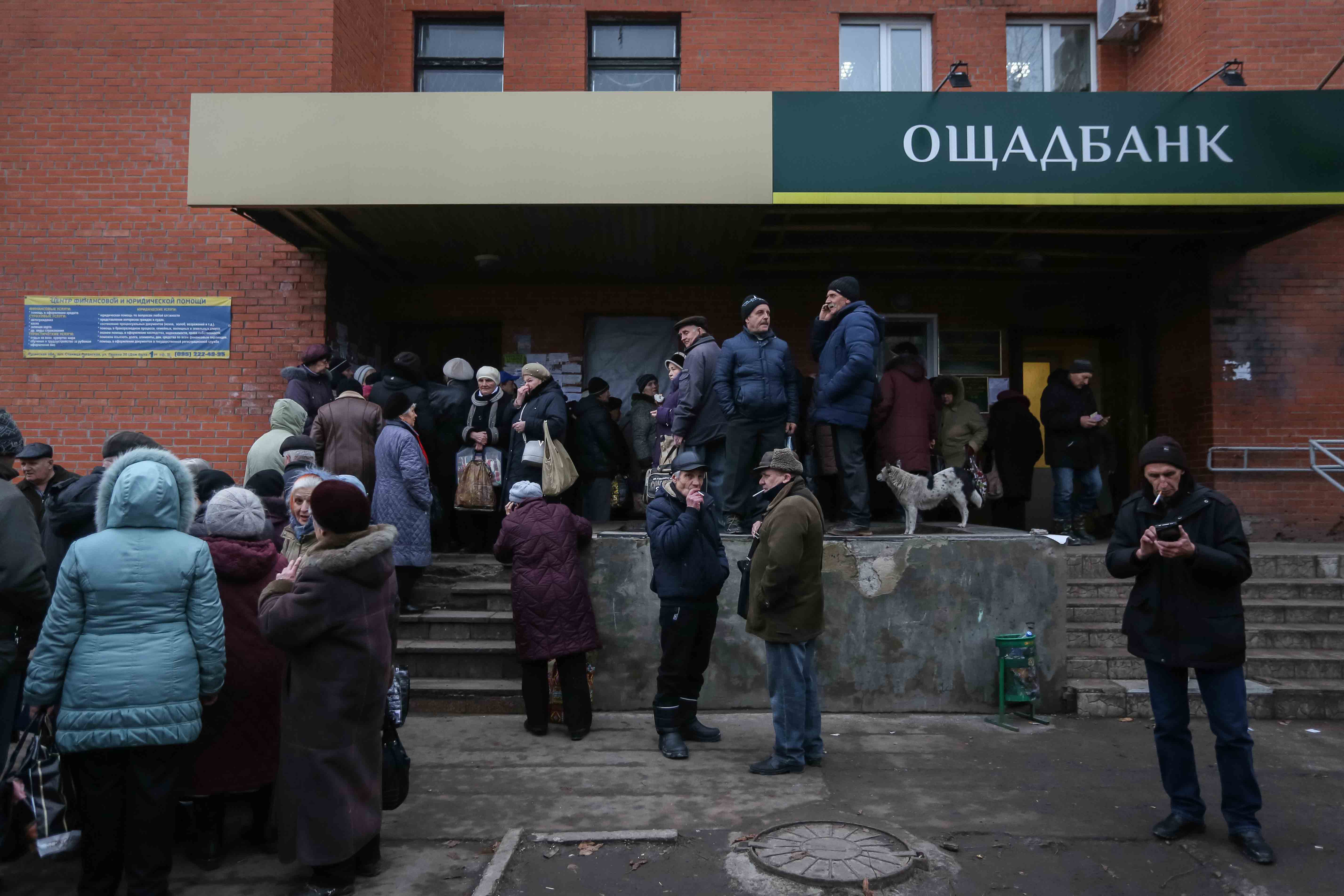 Pensioners stand in line for the bank to get their social security payments on Dec. 14 in Stanytsia Luhanska.
