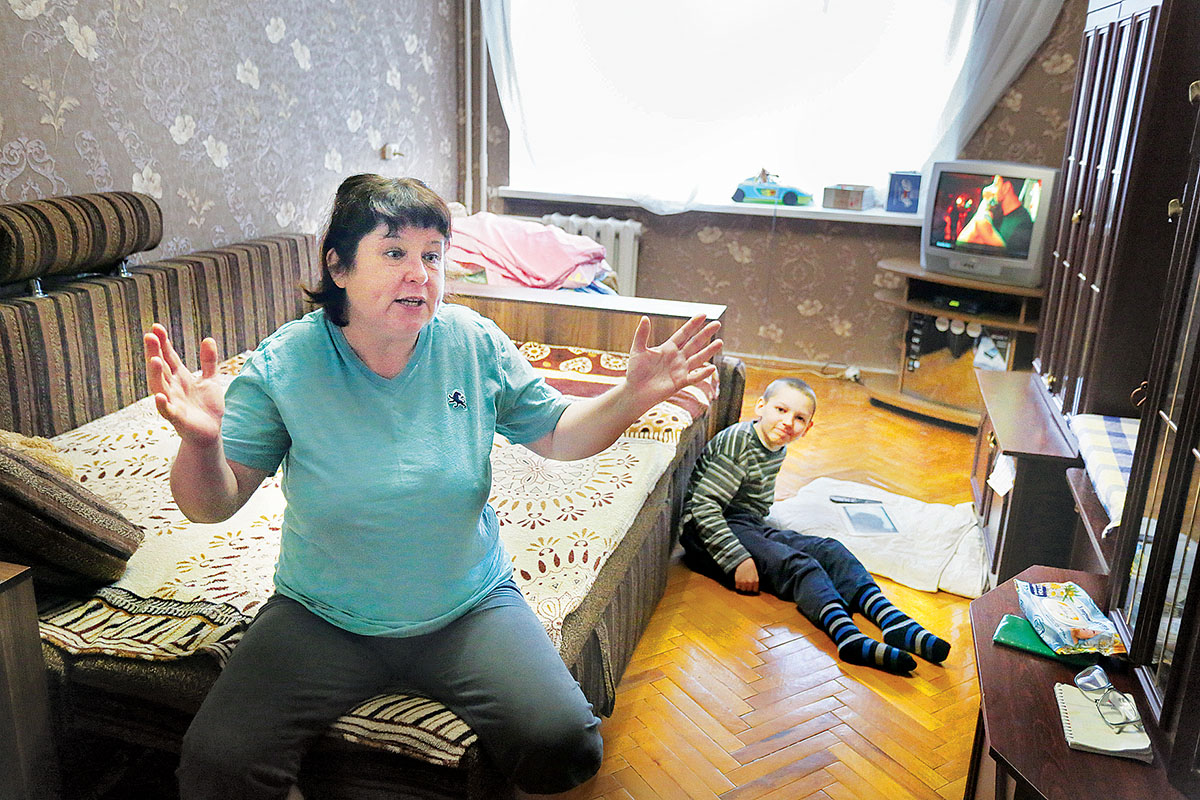 Larysa Chudnenko talks about her life in Berdyansk after she relocated there from eastern Ukrainian Yenakiieve with her grandson Oleksiy in summer 2014. Chudnenko’s 9-year-old grandson suffers from cerebral palsy.  (Oleg Petrasiuk)